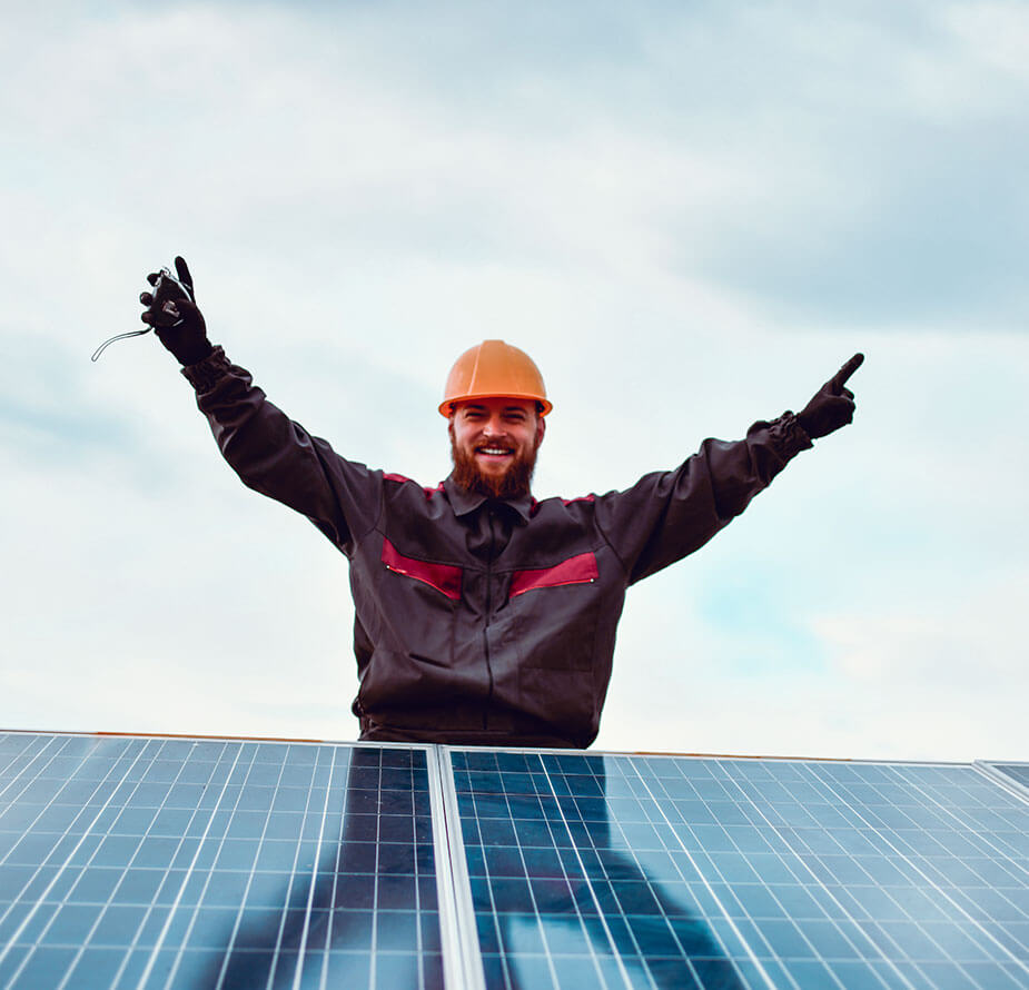 A man in a hard hat, employed by Superior Skilled Trades, is standing on top of a solar panel.
