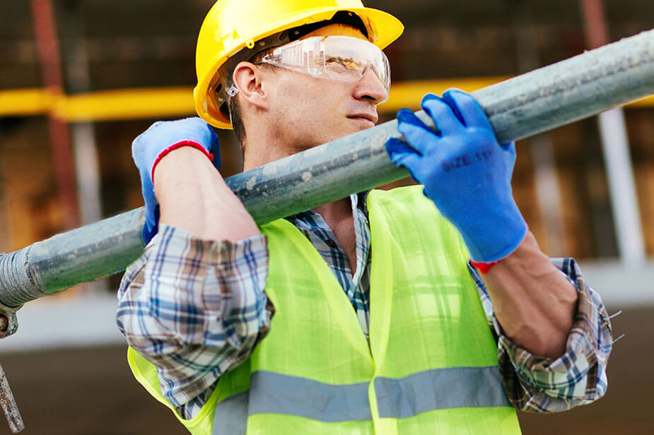 Superior Skilled Trades Industrial Construction staffing employee carrying a pipe on a job site