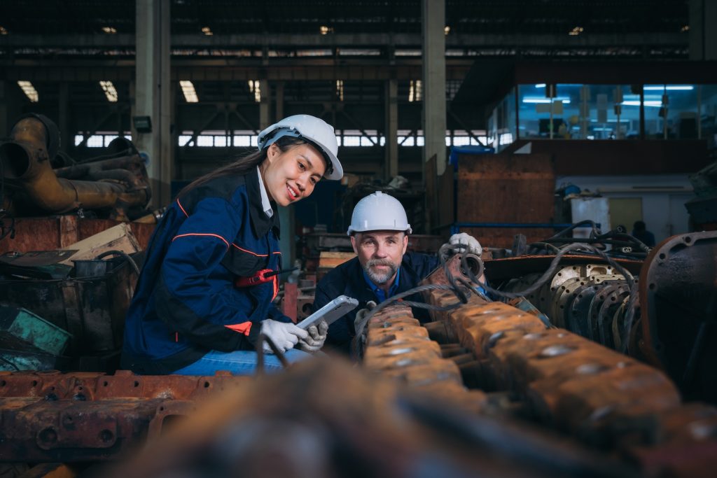 two trades people inspecting some rusty industrial equipment