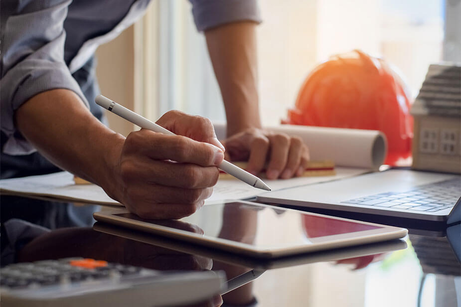 man pouring over documents in a construction office